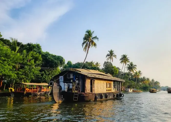 Explore the serene beauty of a houseboat cruising through Kerala's lush backwaters in Alappuzha, India.