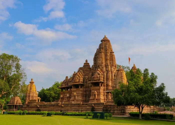 Stunning view of an ancient stone temple surrounded by lush greenery under a clear sky.