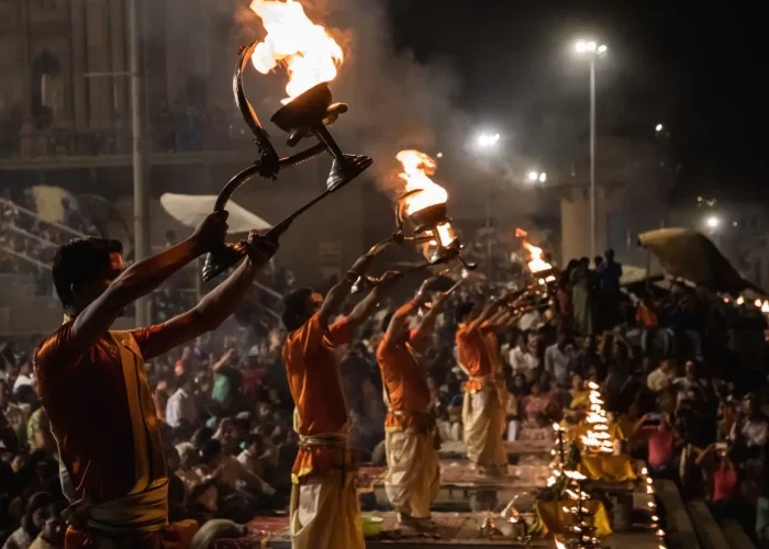 Evening Ganga Aarti ceremony at Dasaswamedh Ghat with priests holding flaming torches.